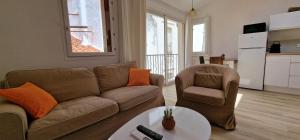 a living room with a couch and a chair and a table at Appartement en bord de mer 3 in Banyuls-sur-Mer