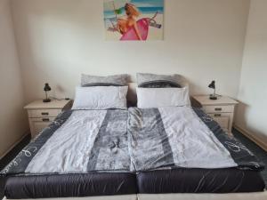 a bed in a bedroom with two night stands at Ferienwohnung Eichhörnchen in Krefeld
