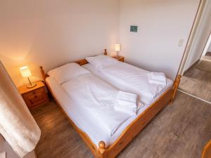 - une chambre avec un lit avec des draps blancs et 2 lampes dans l'établissement Apartment K 40 by Interhome, à Dittishausen