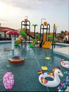 una piscina con parco acquatico con parco giochi di منتجع الجزيرة الخضراء ad Al Hada