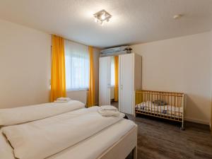 a room with three beds and a crib in it at Holiday Home Quelle by Interhome in Dittishausen