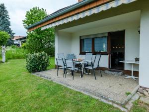 een patio met een tafel en stoelen buiten een huis bij Holiday Home Quelle by Interhome in Dittishausen