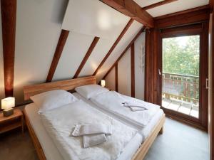 ein Schlafzimmer mit einem Bett und einem großen Fenster in der Unterkunft Holiday Home Am Sternberg 74 by Interhome in Frankenau