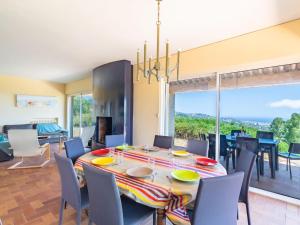 una sala da pranzo con tavolo, sedie e una grande finestra di Holiday Home Mont des Roses by Interhome a Bormes-les-Mimosas