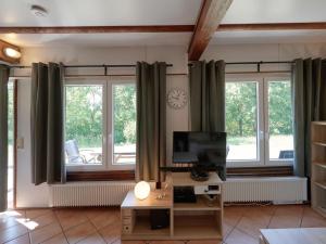 sala de estar con ventanas, escritorio y reloj en Holiday Home Am Sternberg 97 by Interhome, en Frankenau