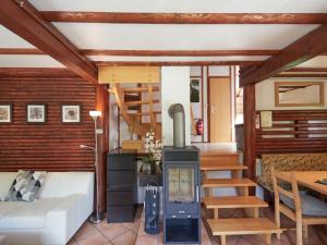 Una sala de estar con chimenea y un sofá. en Holiday Home Am Sternberg 97 by Interhome, en Frankenau