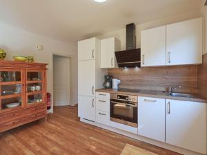 a kitchen with white cabinets and a stove at Apartment Am Sternberg 226 by Interhome in Frankenau