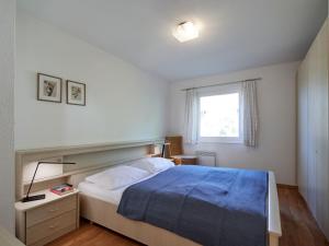 a bedroom with a bed with a blue blanket and a window at Apartment Am Sternberg 226 by Interhome in Frankenau