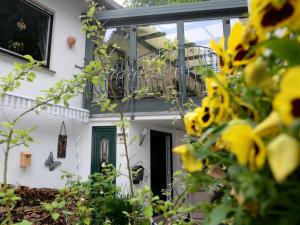 a house with a balcony and yellow flowers in the foreground at Apartment Am Steintisch by Interhome in Schwalenberg