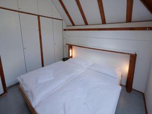 uma grande cama branca num pequeno quarto em Holiday Home Am Sternberg 42 by Interhome em Frankenau