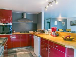 - une cuisine avec des placards rouges et un bol de fruits sur le comptoir dans l'établissement Holiday Home Ty Park - LOQ207 by Interhome, à Locquirec