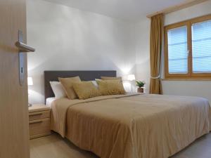 a bedroom with a large bed and a window at Apartment Panoramapark Soleil Haus D Apt 3 by Interhome in Wengen