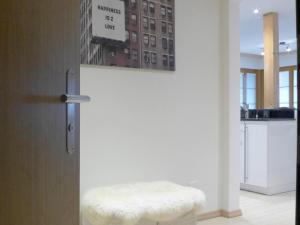 una habitación con un taburete blanco y una foto en la pared en Apartment Panoramapark Soleil Haus D Apt 3 by Interhome, en Wengen