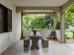 een patio met een tafel, banken en een raam bij Holiday Home Rosalba Bacara by Interhome in Bolsena