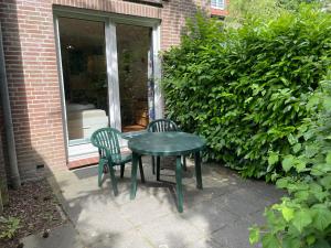een groene tafel en 2 stoelen op een patio bij Apartment Tossens-6 by Interhome in Tossens