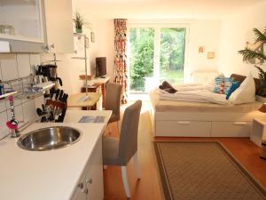 een keuken met een wastafel en een kamer met een bed bij Apartment Tossens-6 by Interhome in Tossens