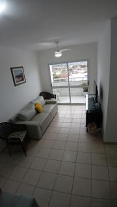 a living room with a couch and a table at Mar, Praia, Sossego e Tranquilidade in Itanhaém