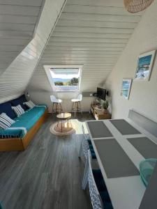 Cette chambre mansardée comprend un lit et un canapé. dans l'établissement Appartement avec vue mer, à Arzon