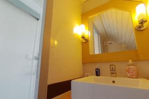 uma casa de banho com um lavatório e um espelho em Appartement avec vue mer em Arzon