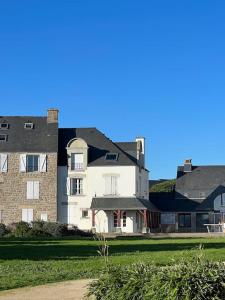 uma grande casa branca e um edifício de tijolos em Appartement avec vue mer em Arzon