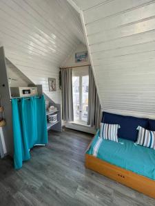 um pequeno quarto com uma cama num sótão em Appartement avec vue mer em Arzon