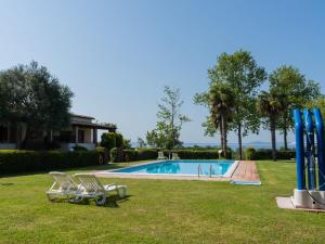 Una piscina con dos sillas de jardín e inflables azules. en Holiday Home Dolce Vita-2 by Interhome, en Bolsena