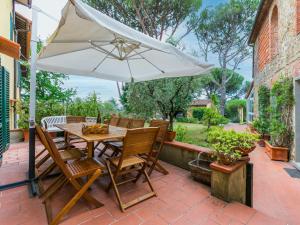 a table and chairs with an umbrella on a patio at Holiday Home Tenuta San Lazzaro by Interhome in Montevettolini