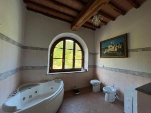 bagno con vasca, servizi igienici e finestra di Villa Bella Costa a Monticello Altre 24 foto