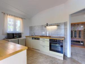 La cuisine est équipée de placards blancs et d'un four avec plaques de cuisson. dans l'établissement Apartment Laura - LBN422 by Interhome, à Labin