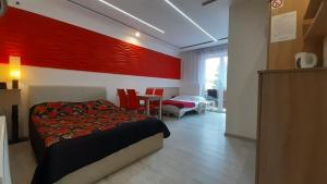 1 dormitorio con cama y pared roja en Pokoje gościnne "Lenka", en Ciechocinek