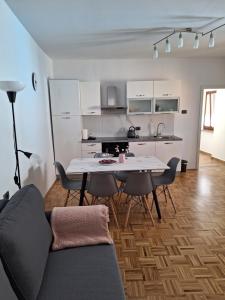 a living room with a table and chairs and a kitchen at Apartment Kp with parking in Koper