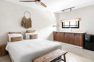 a bedroom with a large white bed and a sink at Hotel Anilevich Mansion in Beer Sheva