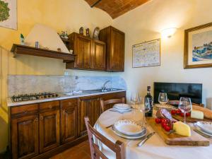 een keuken met een tafel met borden en wijnglazen bij Holiday Home San Rocco-2 by Interhome in Greve in Chianti