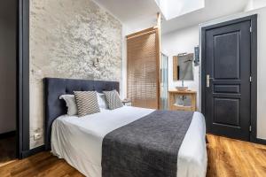 a bedroom with a large bed with a blue headboard at H&ocirc;tel Parc Mazon-Biarritz in Biarritz