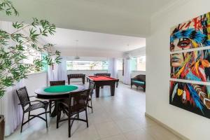 un comedor con mesa de ping pong y una pintura en Apartamento Com Piscina na Praia de Bombas - Apto 2 dorms para 6 pessoas, en Bombinhas