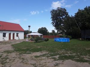 podwórze z białym domem i altaną w obiekcie Agroturystyka Rewita w mieście Darłowo