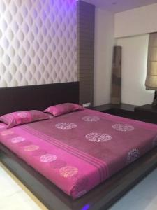 Una cama con colcha rosa encima. en Home away from home! en Anand