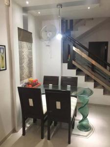 comedor con mesa de cristal y sillas en Home away from home! en Anand