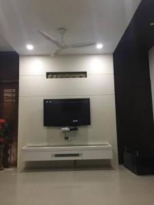 TV de pantalla plana en la pared de la sala de estar. en Home away from home! en Anand