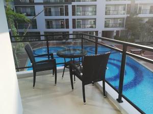 een balkon met een tafel en stoelen en een zwembad bij The Condo 88 Wohnung 42-179 in Hua Hin