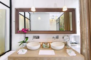 La salle de bains est pourvue de 2 lavabos et d'un grand miroir. dans l'établissement Palais Namaskar, à Marrakech