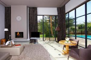 a living room with a fireplace and a tv at Palais Namaskar in Marrakesh