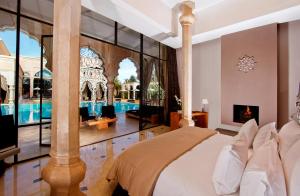 a bedroom with a bed and a swimming pool at Palais Namaskar in Marrakech