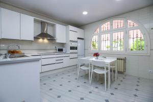 a kitchen with white cabinets and a table with chairs at Calma Villa Planetcostadorada in Salou
