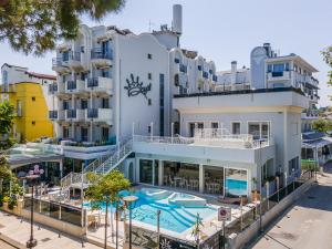 a large white building with a swimming pool at Royal Boutique Hotel NUOVA GESTIONE in Riccione