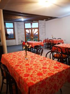 a dining room with tables and chairs with red table cloth at CycloCamp & Hostel in Skorenovac