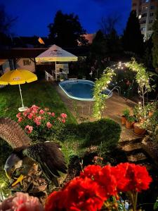 a backyard with a swimming pool and flowers and an umbrella at Ubytovani Na Hrazi 91 in Znojmo