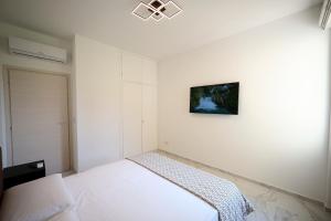 ein weißes Schlafzimmer mit einem Bett und einem Bild an der Wand in der Unterkunft Dreamich - Delle Rive in Desenzano del Garda