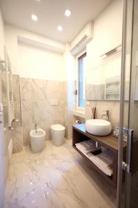 ein Badezimmer mit zwei Waschbecken, einem WC und einer Dusche in der Unterkunft Dreamich - Delle Rive in Desenzano del Garda