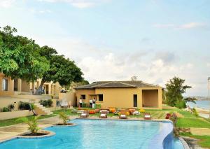 a swimming pool in front of a house at Bilene Lodge by Dream Resorts in Vila Praia Do Bilene